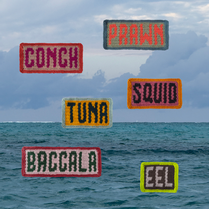 Crochet patches with seafood and fish names floating over an ocean scene